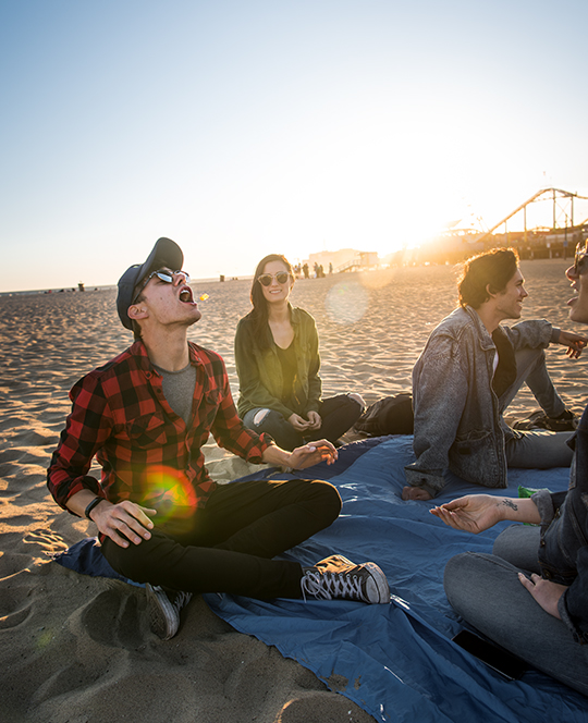 People on a beach blanket eating candy